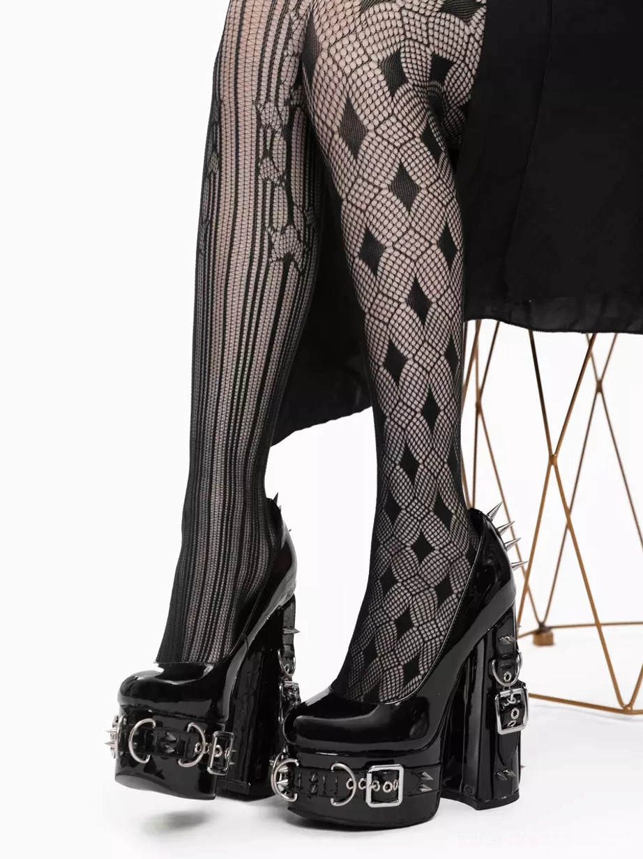 Gothic platform pumps seated front view model on wire chair wearing mixed pattern stockings multiple silver rivets