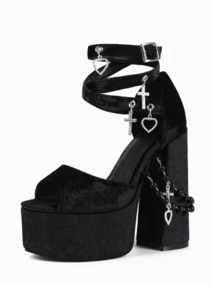 Black velvet gothic lolita platform sandals left three-quarter view showing cross heart charm decorations ankle buckle strap peep toe design