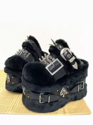 Front three-quarter angle of punk goth platform sandals featuring dual leather straps spiked metal studs and skull spade buckle decorative charms