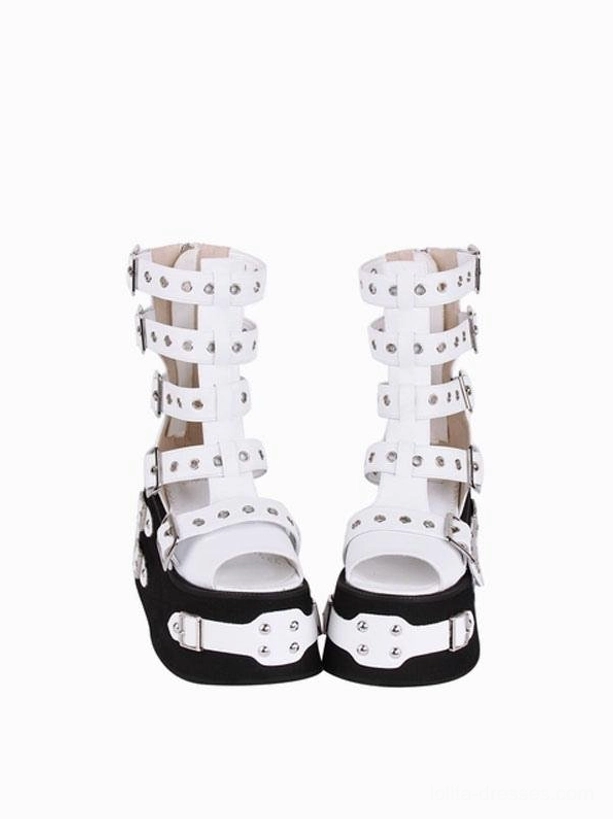 Pair of Gothic Lolita platform gladiator sandals front low-angle view highlighting fully studded ankle buckle straps, open round toe design, and black soles with decorative silver accents