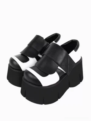 Gothic Lolita black and white two-tone platform shoes front three-quarter view showing pair with wide velcro strap, round toe, and chunky segmented outsole