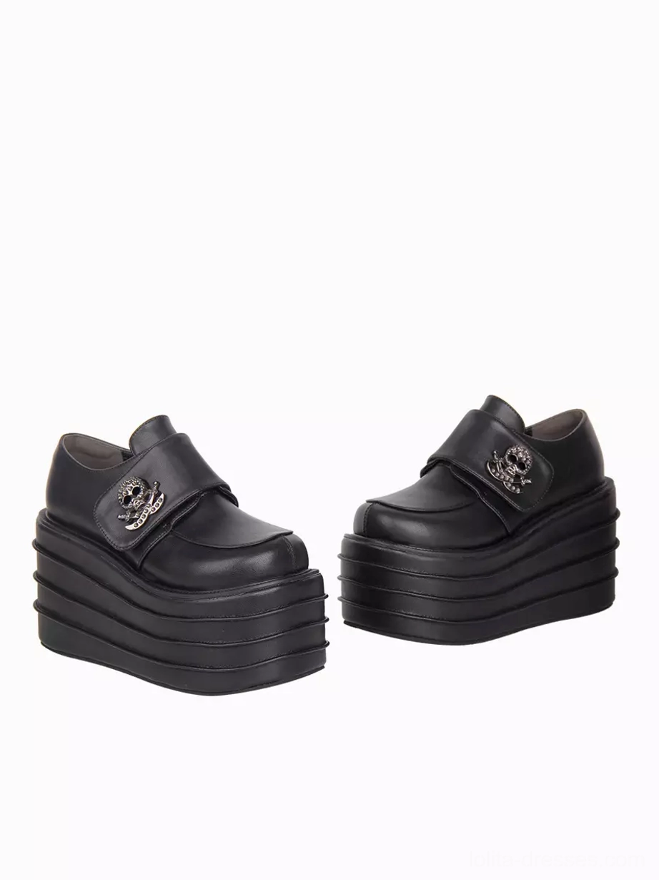 Pair of gothic lolita platform shoes low frontal side angle emphasizing skull metal decorations and stacked thick platform sole layering for height