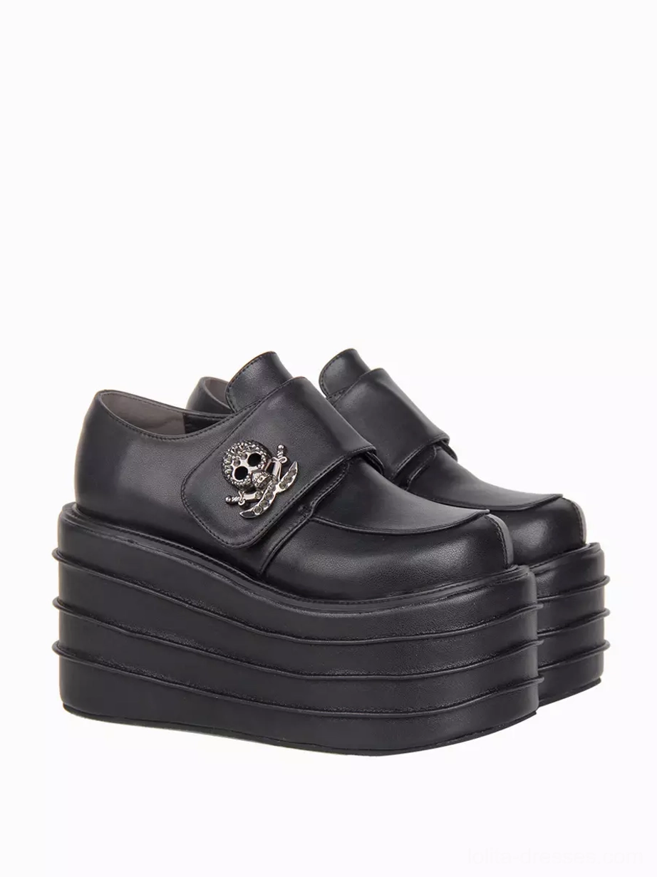 Right side three-quarter view of gothic lolita platform shoes highlighting round toe silhouette, layered wedge heel architecture, and skull metal ornament placement