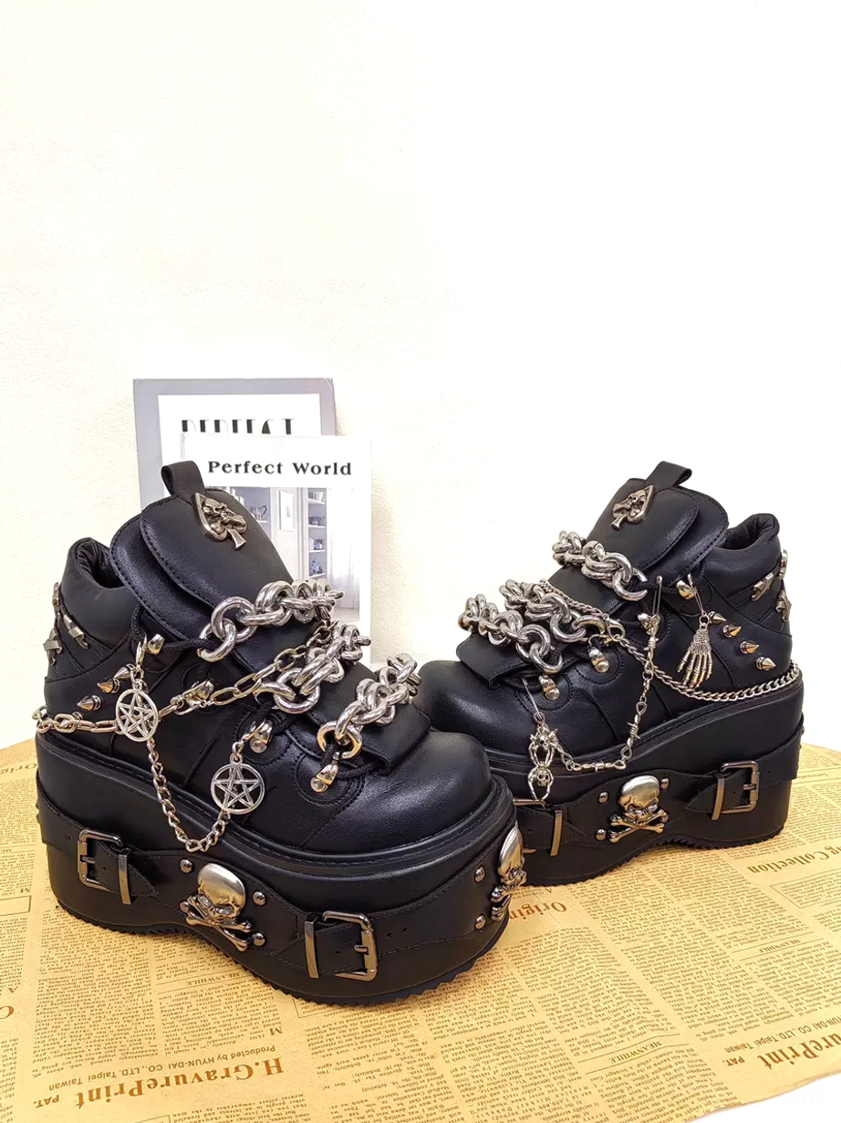 Gothic lolita platform shoes three-quarter side view book and newspaper props black leather pentagram pendants silver chains skull hardware sole