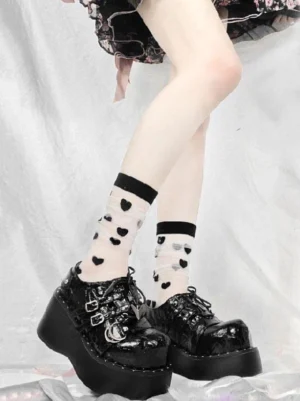 Black gothic lolita platform shoes side angle showing thick platform sole lace-up closure and heart-print sheer socks detail