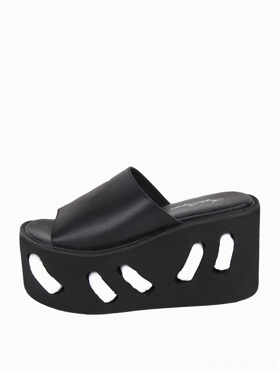 Close-up single black lolita platform sandal side profile showcasing detailed geometric cutout pattern on substantial wedge sole and open toe structure