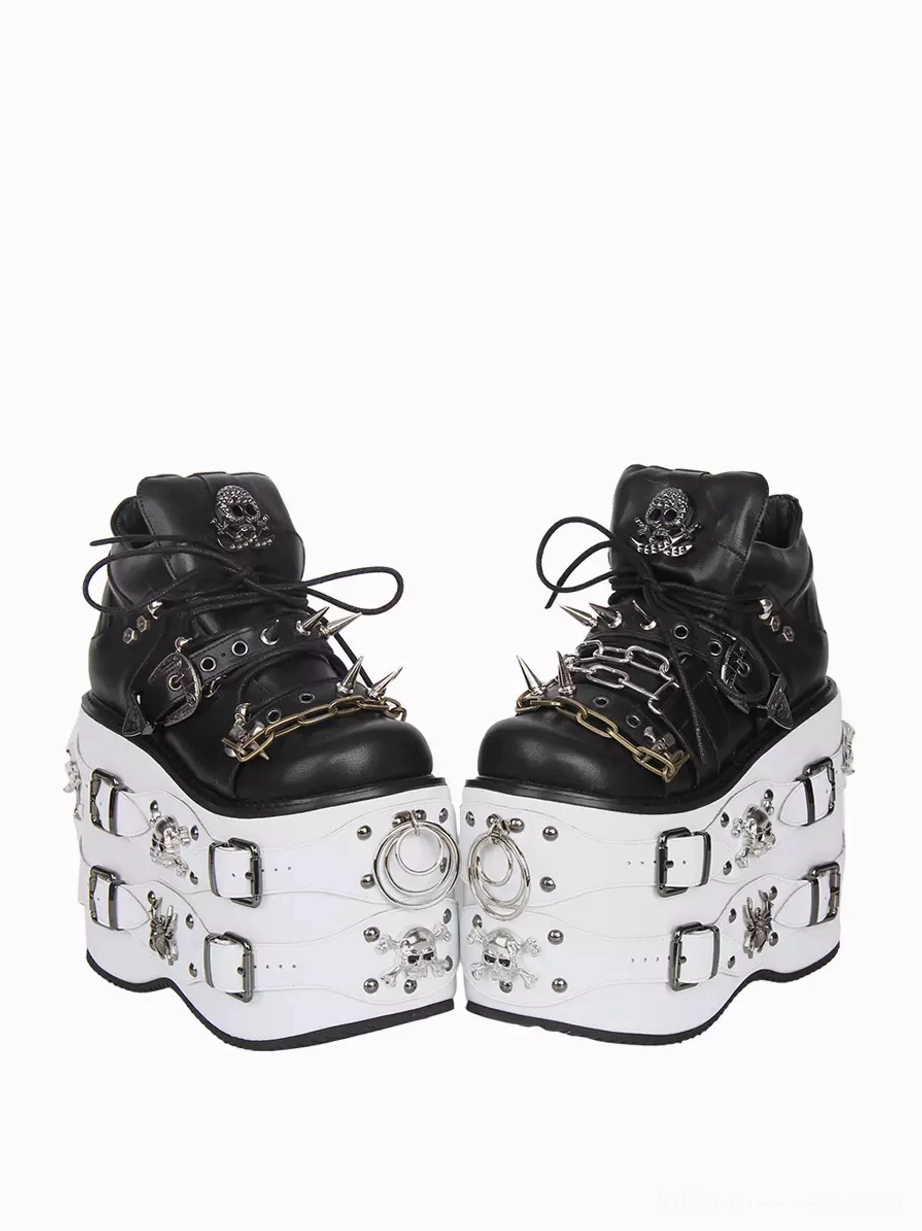 Paired Gothic Lolita platform wedge shoes front three-quarter viewing angle black upper with metal chain and spike details white thick sole with square buckles and skull spider motifs