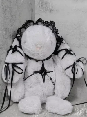 White fluffy rabbit shoulder bag front view with black lace headdress and cross star decorations, concrete wall background, black ribbon shoulder strap, gothic lolita accessories
