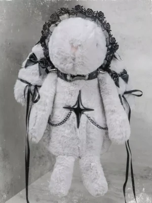 White plush rabbit crossbody bag with black lace trims and decorative chain accents, flat lay view against vintage background, featuring star and cross embellishments and black ribbon bows for gothic lolita style