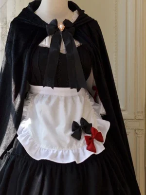 Gothic maid lolita cape set with ornate gem brooch bow centerpiece, white ruffled apron, matte black velvet fabric front center view