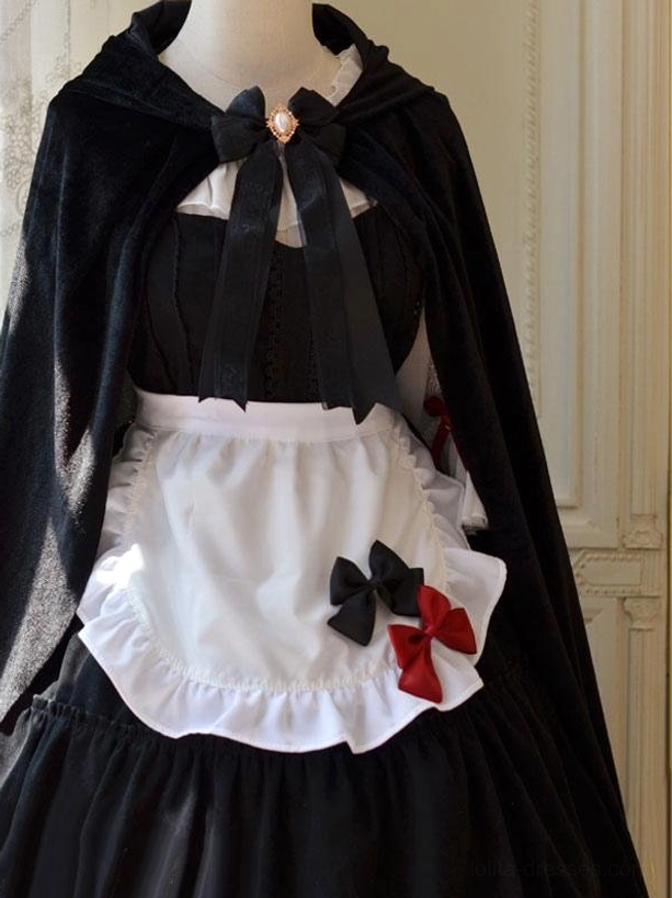 Gothic maid lolita cape set with ornate gem brooch bow centerpiece, white ruffled apron, matte black velvet fabric front center view