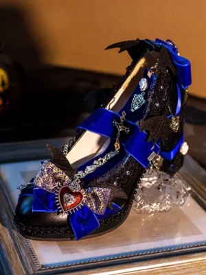 Gothic lolita pump front view featuring royal blue ornate bow with heart charm, black glitter upper with delicate cross chain embellishment