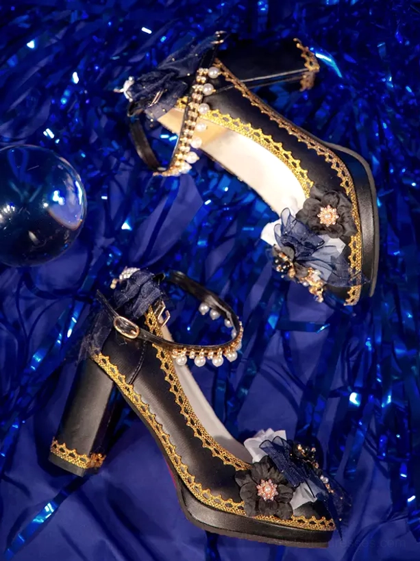 Oblique side angle Gothic Lolita platform pumps with blue tinsel and glass props background showing pearl-adorned ankle strap dark blue fabric bow decorations clearly visible