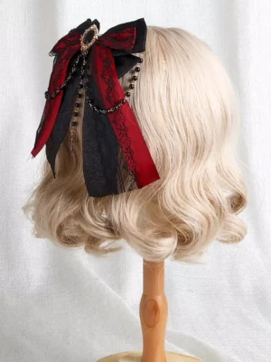 Gothic Lolita bow hair accessory left side view showing red-black layered bow construction with beaded chain tassels hanging from wig display stand