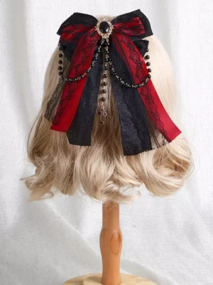 Gothic Lolita red and black two-tone bow headdress front three-quarter view with satin bows, lace trim, gem brooch and beaded cross pendant on blonde curly wig mannequin