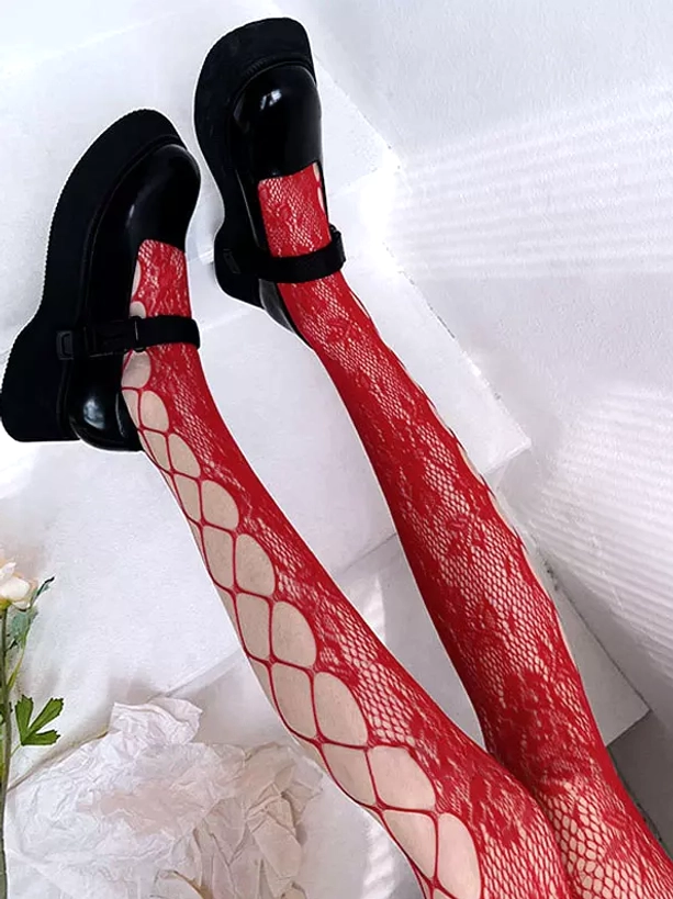 Red patchwork fishnet lace stockings low-angle view featuring red floral lace and large rhombus hollow net pattern, coordinated with black Mary Jane shoes and decorative fabric props