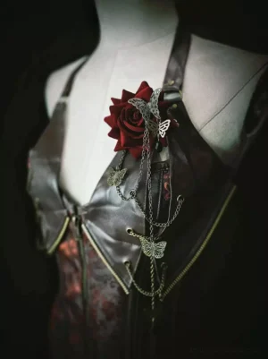 Gothic Lolita deep red rose chain corsage brooch with antique silver butterfly charms and dangling metal chains displayed on dark leather bustier three-quarter front view