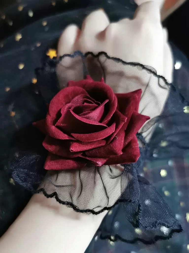 single gothic lolita rose wrist cuff with scalloped black lace edge and burgundy rose embellishment, side close-up profile view worn on hand against dark star-moon printed fabric