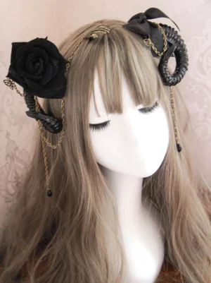 Gothic lolita sheep horn rose hair clip with metal chain tassels black satin bow displayed on mannequin with long brown wig against pink vintage patterned wall background