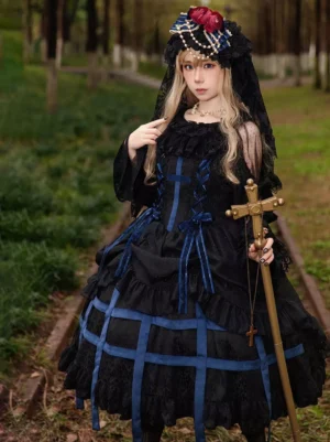 Gothic Lolita sleeveless jumper dress with deep blue cross ribbon trim and multi-layer ruffled skirt, black color option front view on model with vintage headdress and cross scepter in outdoor forest railway setting