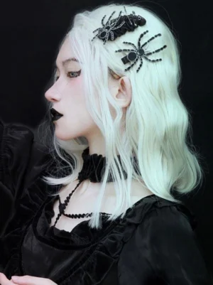 Gothic Lolita black spider hair clips worn on platinum wavy wig with black matte finish and metal wire legs, styled with gothic black dress and black choker necklace, left side profile view