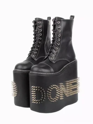 Black Gothic Lolita platform boots front view featuring round toe silhouette, spike letter embellishments, lace-up design, and dramatic wedge heel against white background