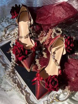 Burgundy wine red Gothic Lolita stiletto pumps with pearl chain ankle ornament, red silk roses, gold chain accents on black tray with lace and tulle