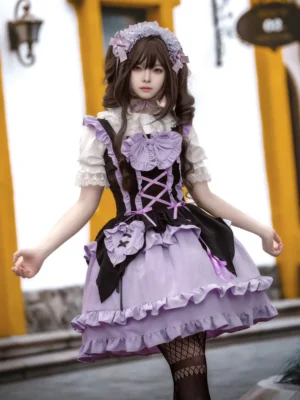 Gothic Lolita suspender dress in purple and black with lace-up front bodice and ruffled layered skirt, front three-quarter view worn by cosplayer at European building