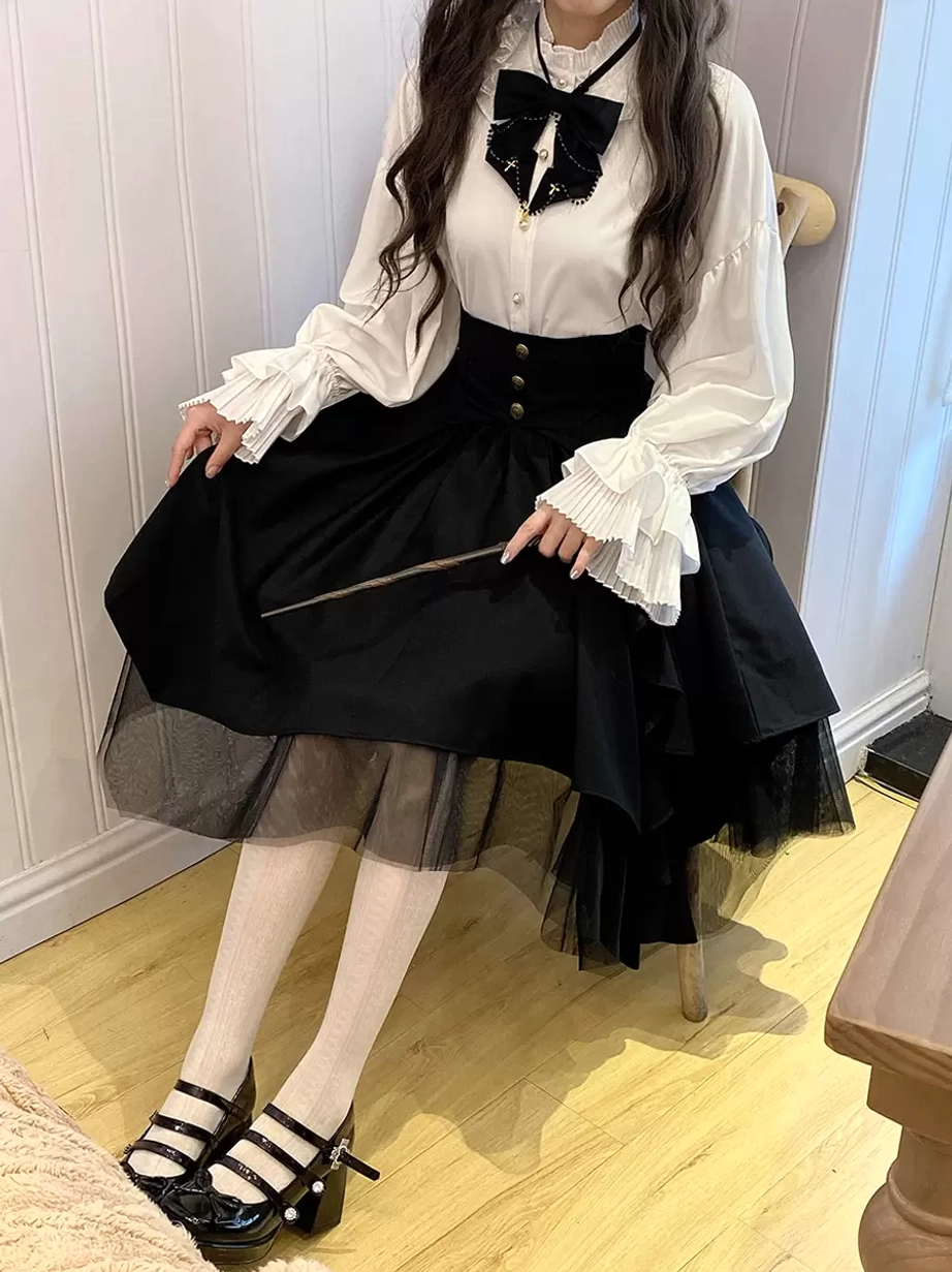 Gothic lolita tiered skirt side three-quarter seated view showing asymmetrical layered tulle hem white stockings and mary jane shoes with bow accessory