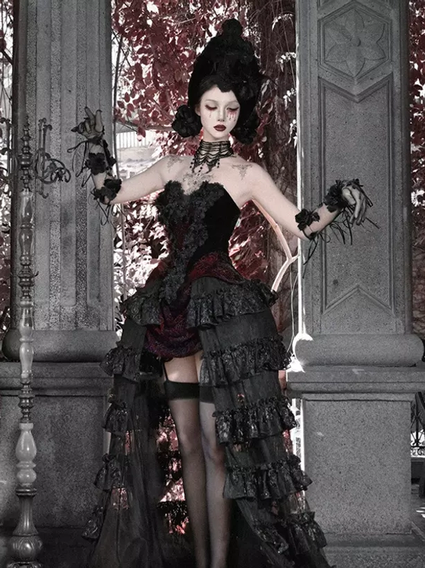 Gothic black and red lolita gown with multi-layered ruffled tiered skirt and necklaces, full front shooting angle featuring model with updo gothic styling at stone pillar terrace setting