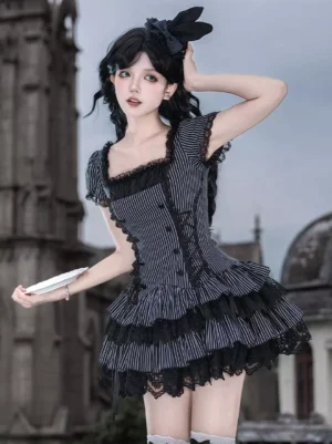 Three-quarter side view of gothic lolita dress showing fitted corset waist and multi-tiered lace-trimmed ruffle skirt with vintage building backdrop