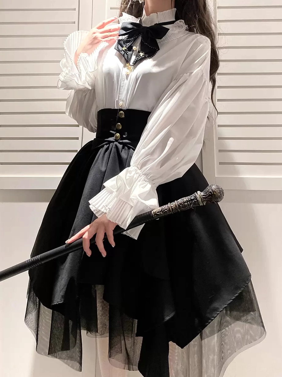 Black tiered gothic lolita skirt three-quarter view showing irregular layered design sheer tulle underlayer gold buttoned waist with vintage walking stick prop