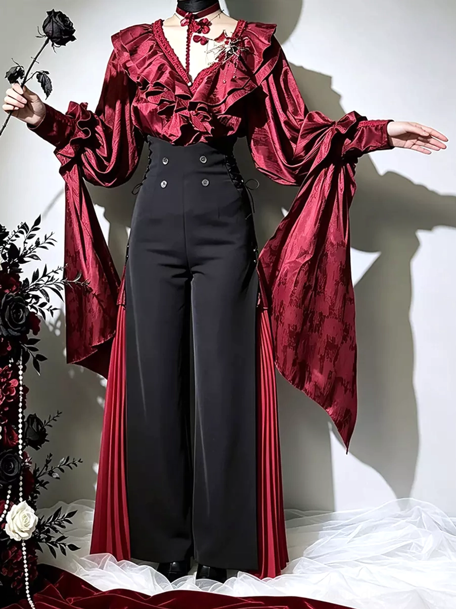 Front full-body view of gothic lolita two-piece ensemble: ruffled burgundy long-sleeve blouse paired with high-waist double-breasted black wide-leg pants and red pleated accent strips