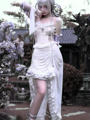Gothic Lolita white dress with detachable lace-up sleeves, corset top, and high-low ruffled skirt standing in Japanese garden setting with horn hair accessories, front full-body shot