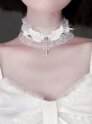 White gothic lolita lace choker with rhinestone cross pendant and wing accents, front close-up on model wearing white lace top, showcasing delicate ruffled design