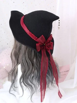 Gothic Lolita witch hat side rear view featuring wine red ribbon trim, dimensional rose bow, and bead-star pendant hanging from black fabric crown