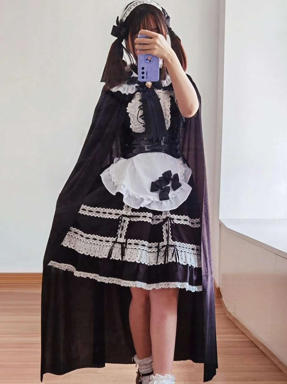 Full gothic maid lolita cape dress set complete with lace-trimmed skirt, hair bow headband, full-length black cape front view on real model