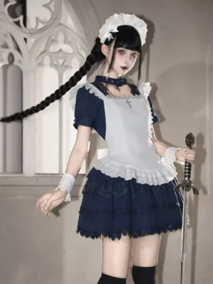 Gothic maid Lolita one-piece dress front three-quarter view in dark navy with white lace trim, worn by model in gothic church setting with cross pendant choker