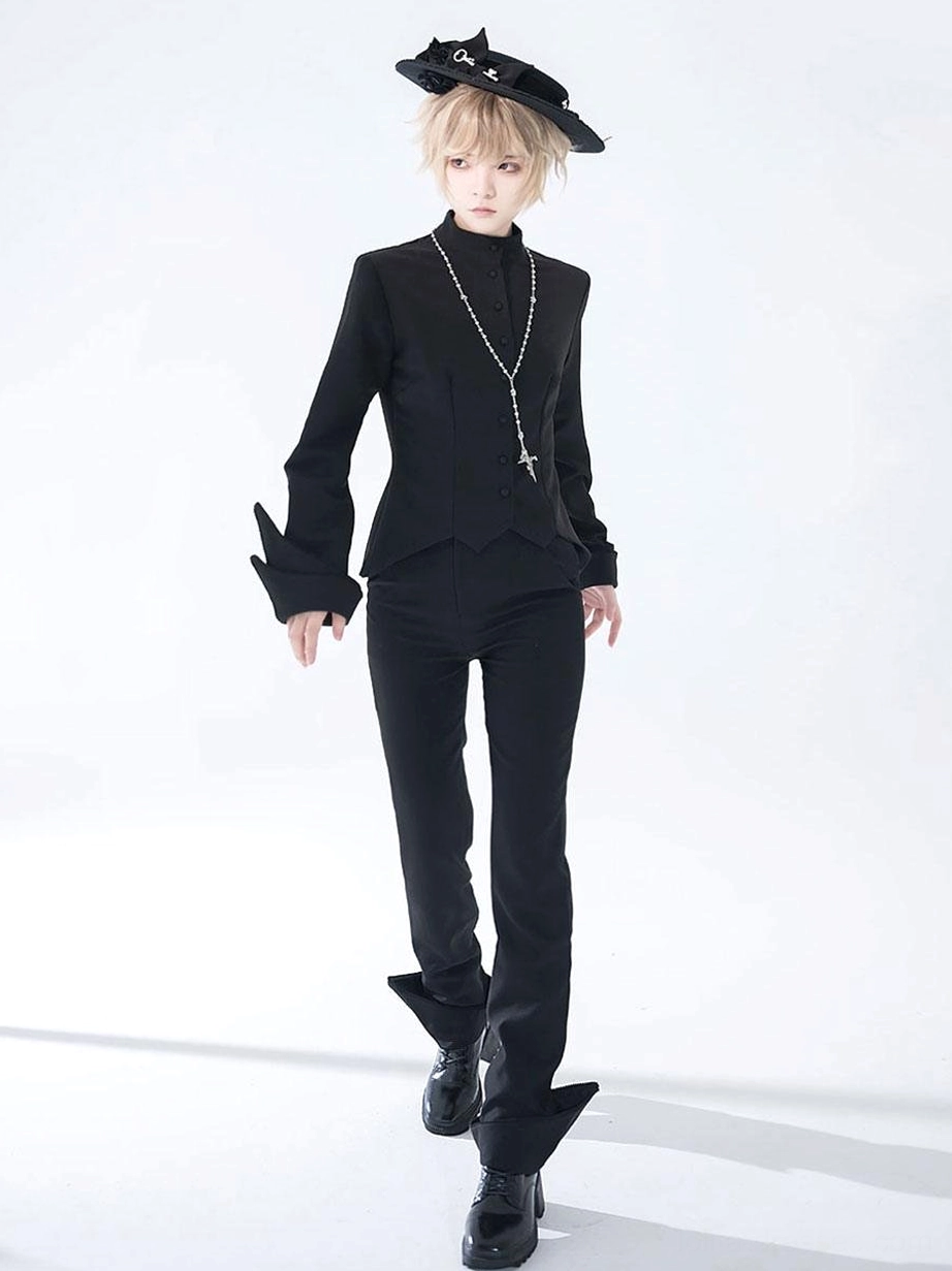 Model wearing complete Gothic Ouji outfit with straight-leg black pants tailored jacket cross pendant necklace full body front view