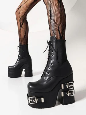 Front view of chunky black platform ankle boots featuring multiple silver buckles, thick block platform sole, and lace-up closure against white studio background