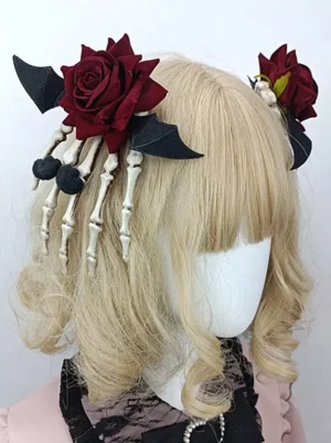 Gothic steampunk lolita rose hair clip with wine-red velvet rose, skeleton hand, and bat wing embellishments displayed on blonde curly wig with lolita collar from back three-quarter view