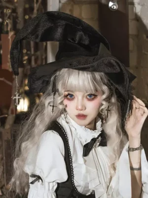 Black velvet gothic witch lolita headdress with cross charm worn by silver-haired model in vintage shop setting, paired with ruffled white shirt and black suspender skirt for complete gothic lolita coord