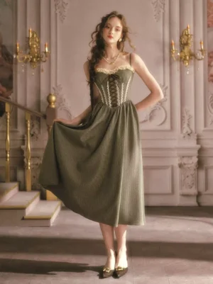 Vintage sage green fairy corset dress three-quarter view showing flowy A-line midi skirt lace-up front and pointed-toe heels on model at ornate staircase
