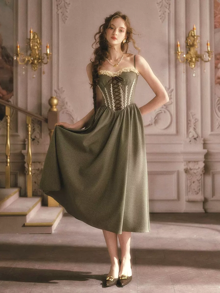 Vintage sage green fairy corset dress three-quarter view showing flowy A-line midi skirt lace-up front and pointed-toe heels on model at ornate staircase
