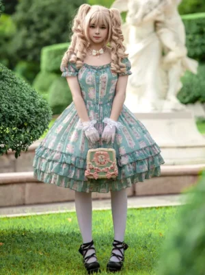 Full body front view of green sweet Lolita dress worn with white lace gloves, matching handbag, and platform shoes on garden lawn background