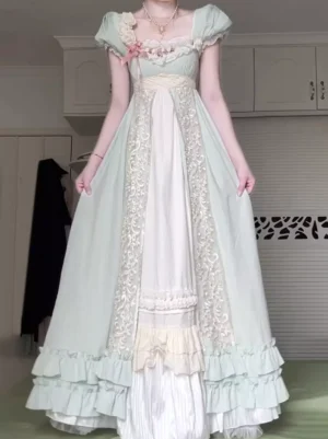Green lolita dress showing empire waist construction, embroidered lace side panels, and layered ruffled skirt hem with white contrast accents - front view detail