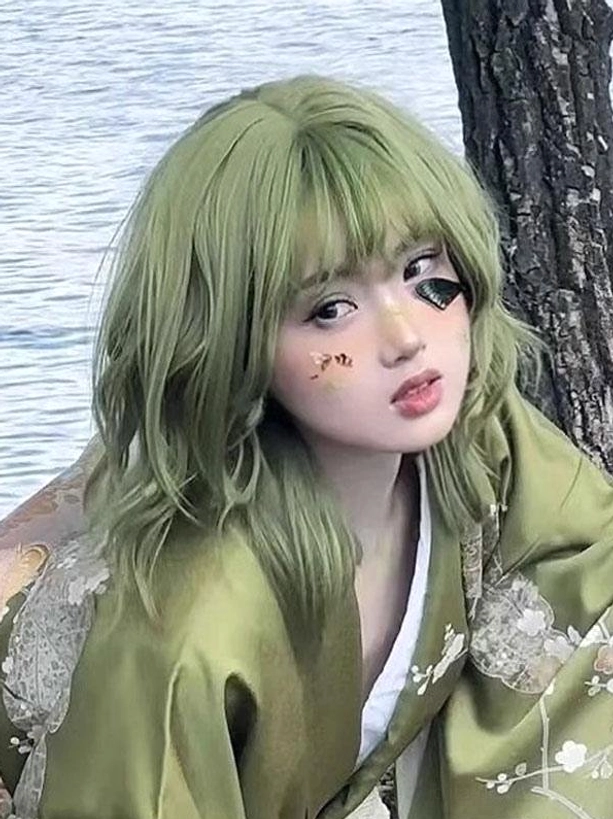 Short green lolita wig front three-quarter view with air bangs, decorative face makeup and matching kimono by lakeside