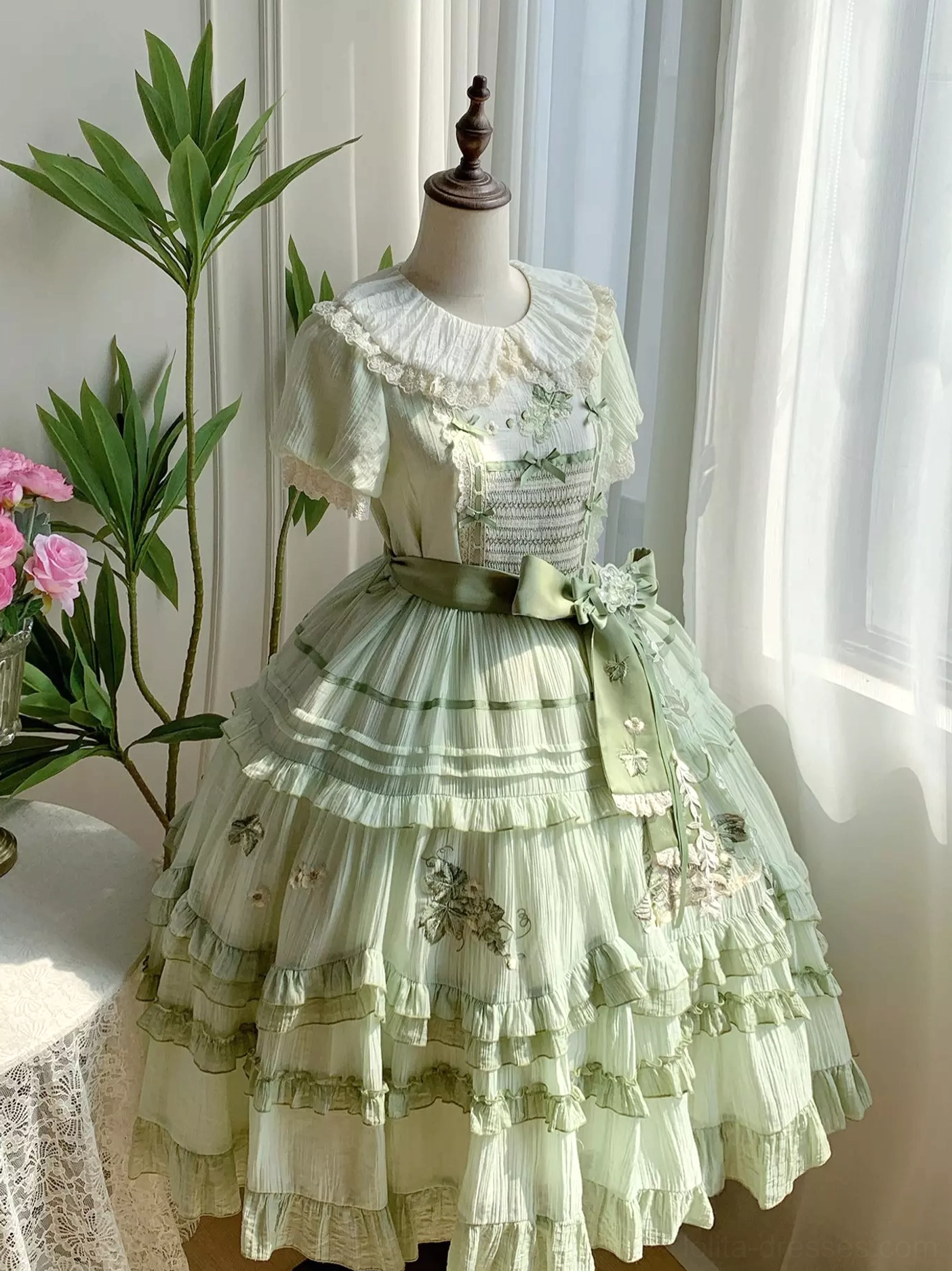 Size comparison and fit guide for green sweet lolita dress showing garment proportions, puffed sleeve silhouette, waist sash placement, tiered ruffled skirt volume across different sizes