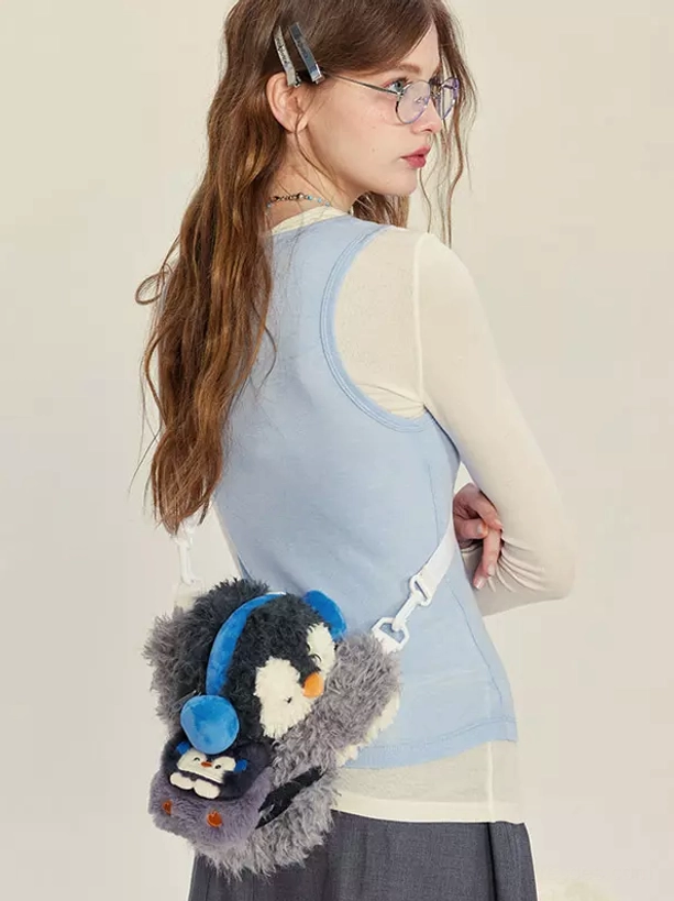 rear back view of model wearing penguin plush crossbody bag matching blue top studio background lolita accessory