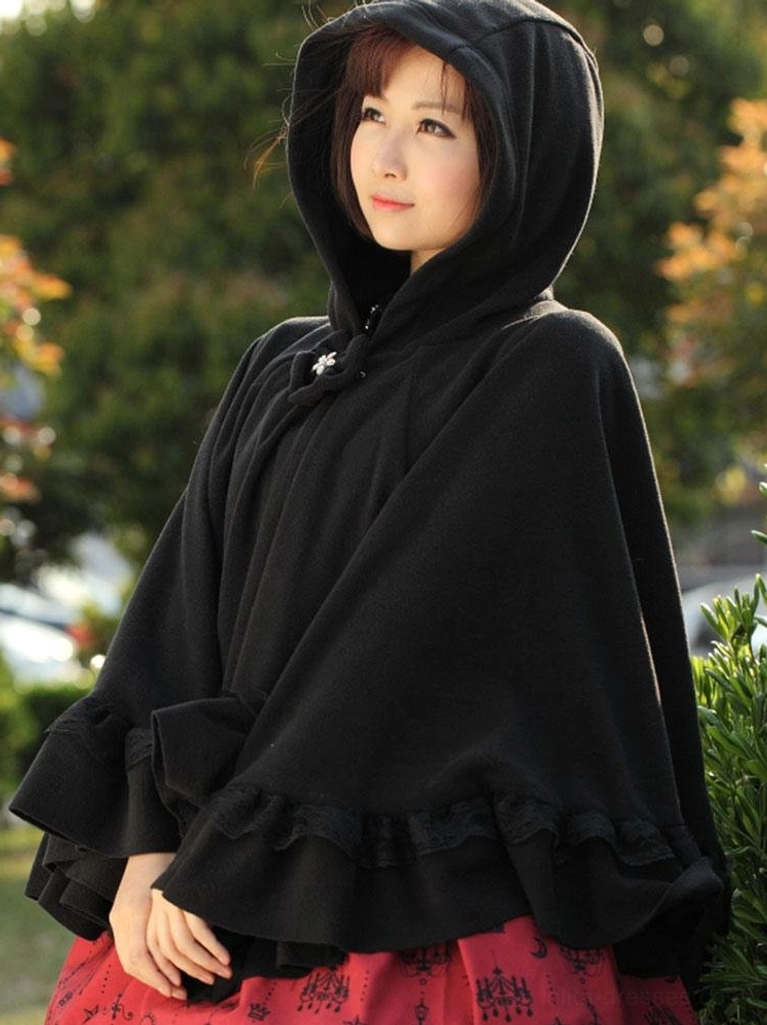 Right side bust-up shot of black hooded lolita cape coat displaying wide ruffled hem and solid black fabric texture